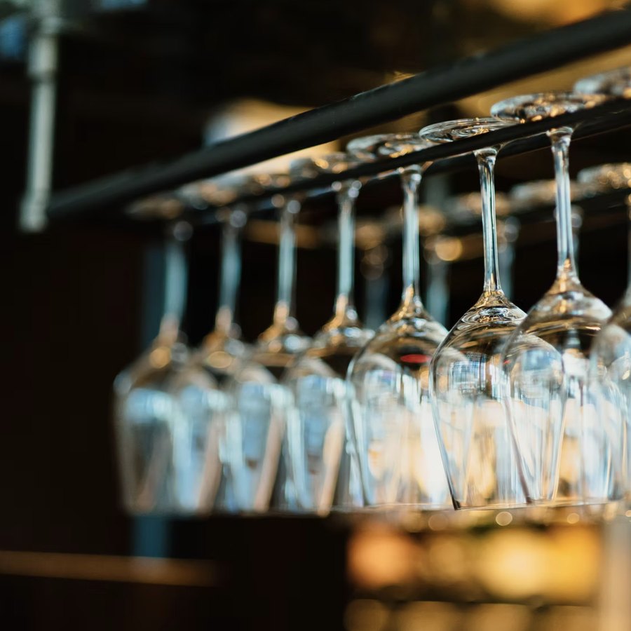 Hängende Weingläser über der Bar im Rossini